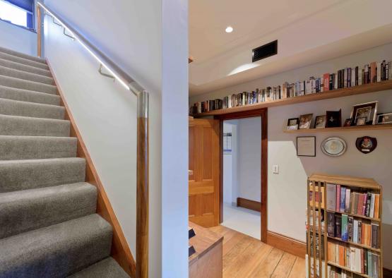 a staircase with bookshelves and a shelf on the wall