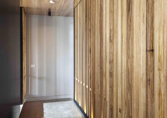 a hallway with wood panels and a bench