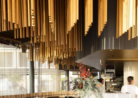 a restaurant with wooden rods from the ceiling