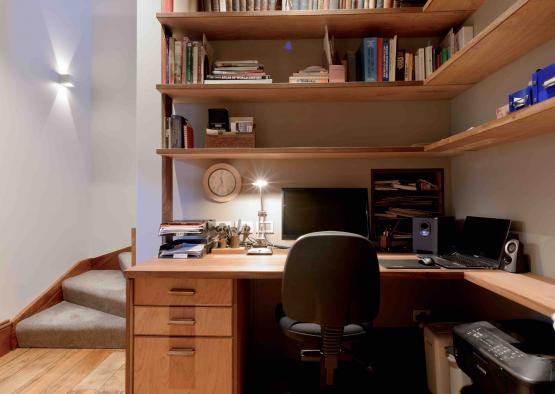 a desk with a computer and shelves in a room