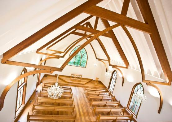 a church with wooden benches and chandeliers