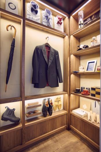 a coat on a swinger in a room with shelves and objects