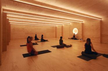 a group of people sitting on mats in a room with a light