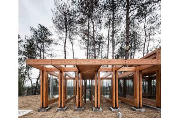 a wooden structure with glass walls and trees