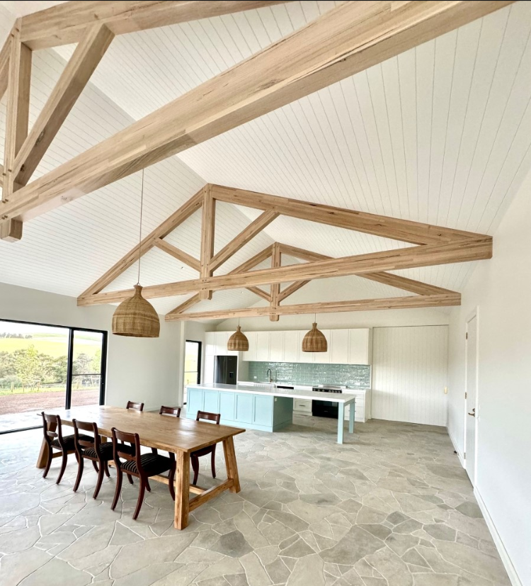 light timber exposed roof trusses in a dining and kitchen area