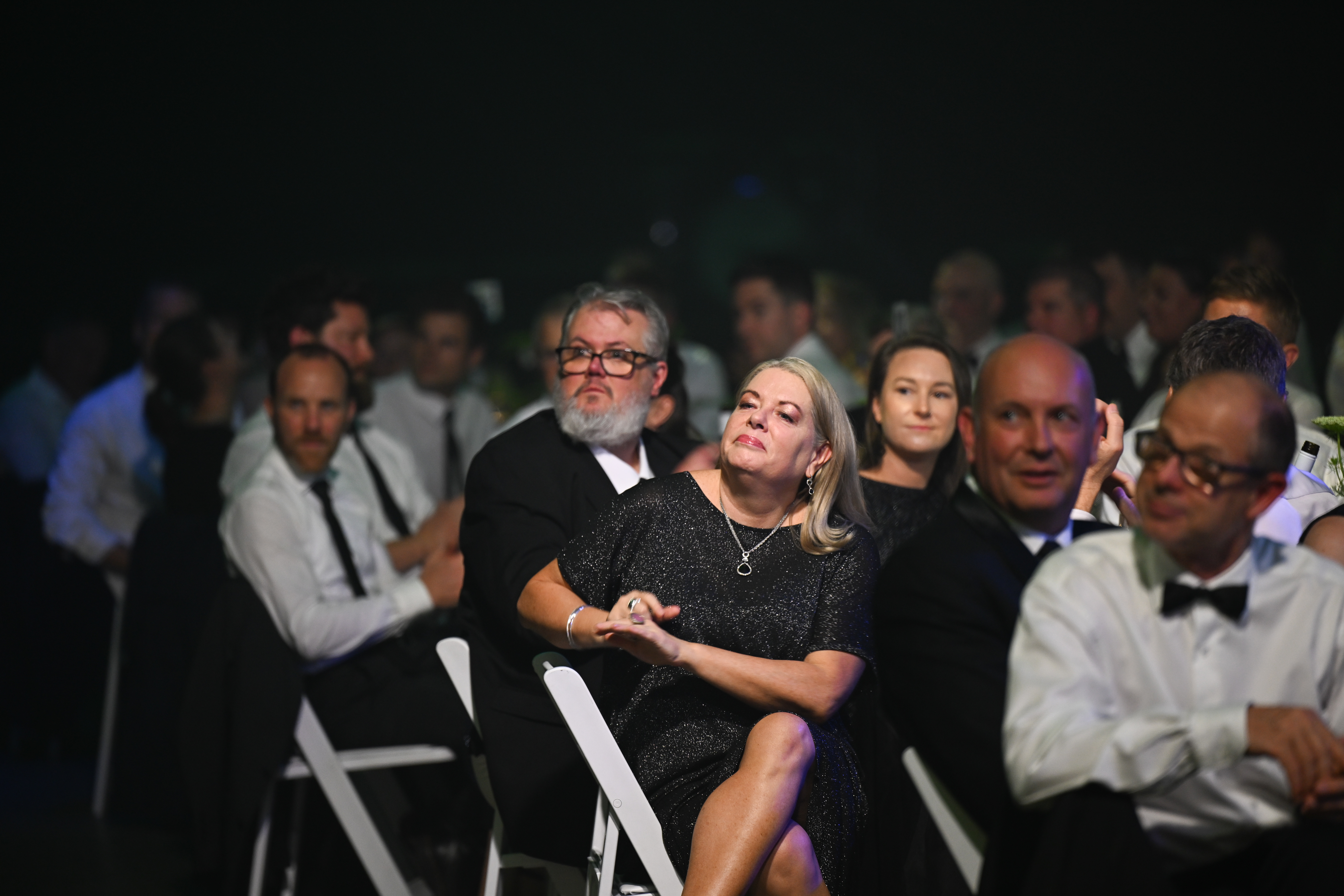 People seated looking on as winning projects are announced at an awards show.