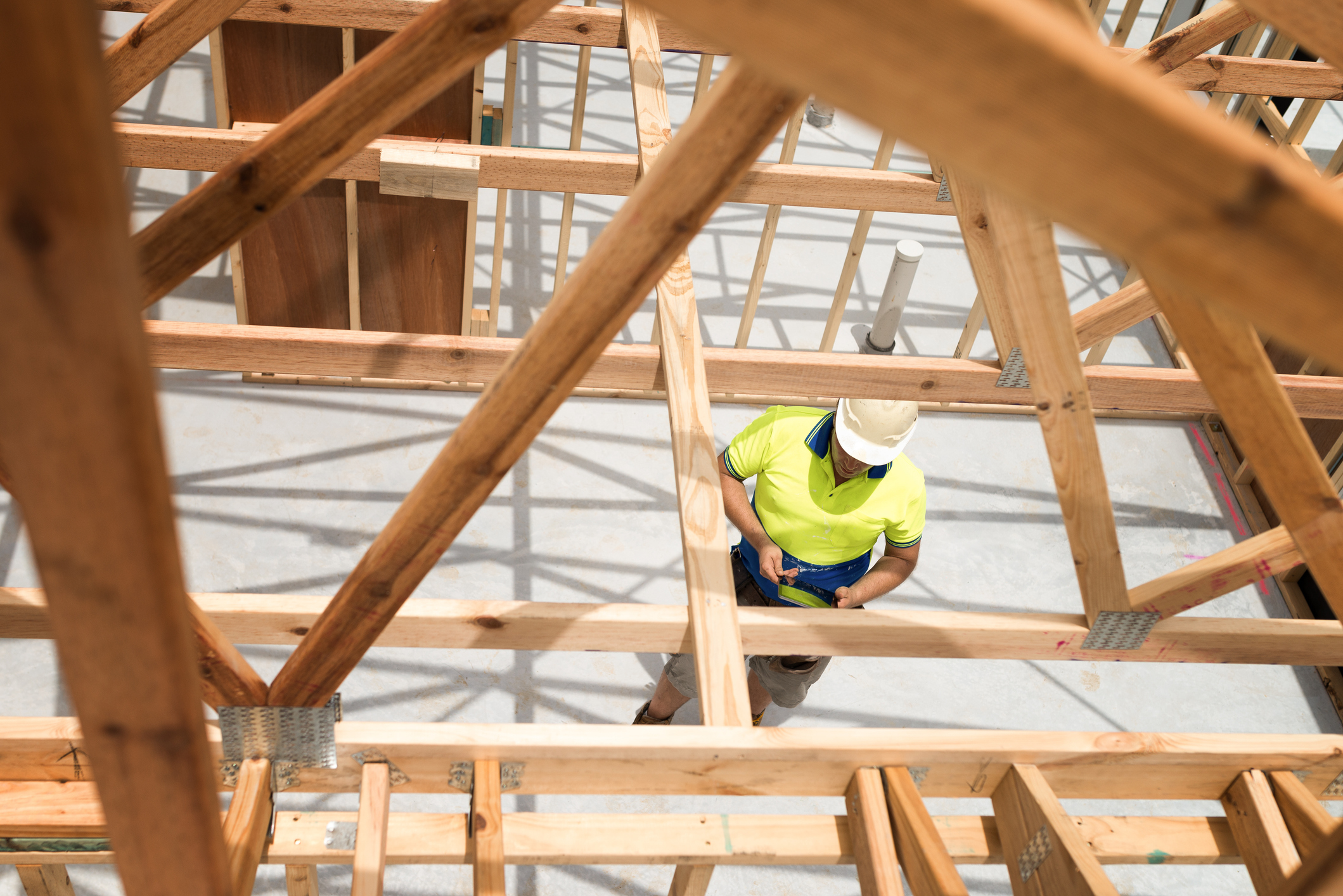 Looking down through timber frame at builder on site