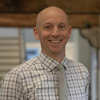 A photo of a bald man in a shirt and tie