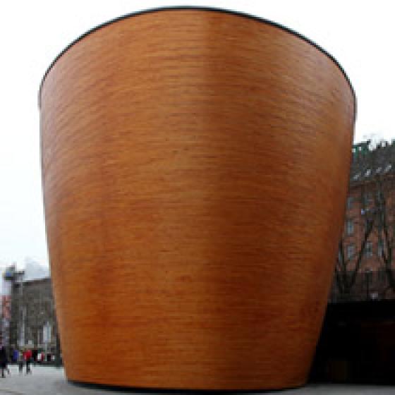 a large wooden pot on a sidewalk