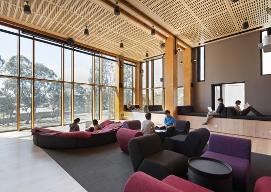 a group of people sitting in a room with large windows