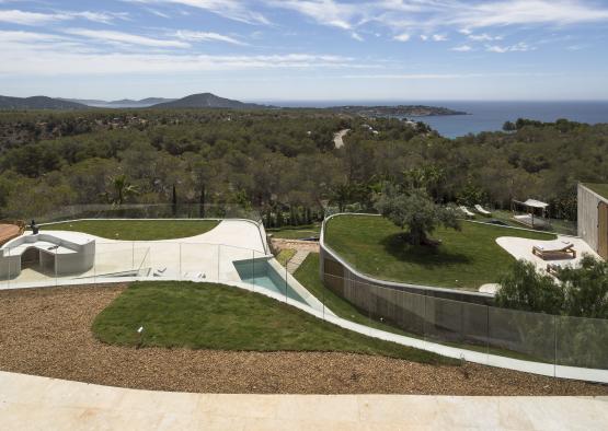 a pool and trees with a body of water in the background