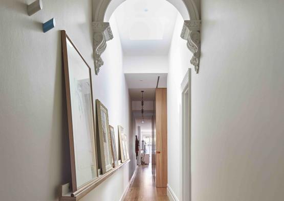 a hallway with white walls and a wood floor