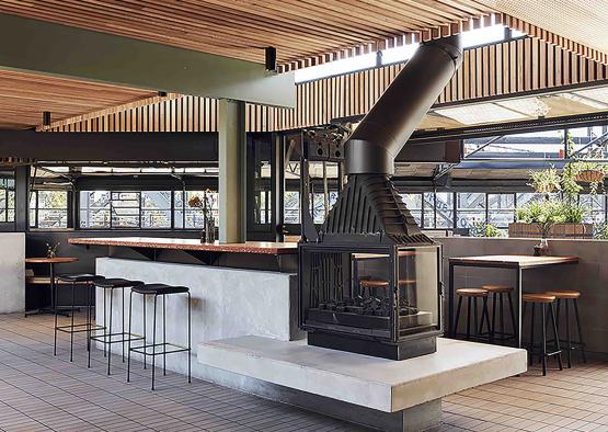 a room with a fireplace and bar stools