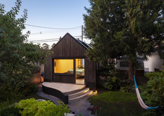 a small house with a slide and a tree