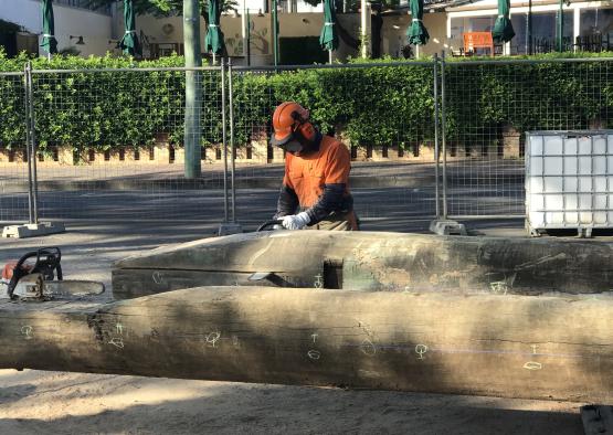 a man in orange gear with chainsaw