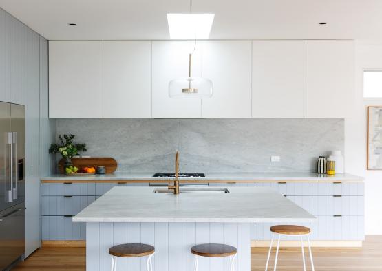 a kitchen with a white island and stools
