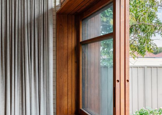 a window with wood slats and a wooden bench