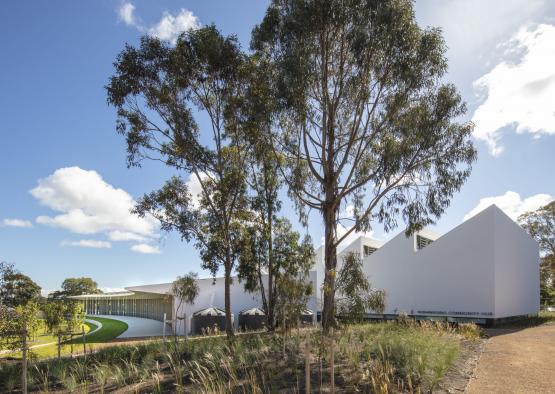 a white building with trees and grass