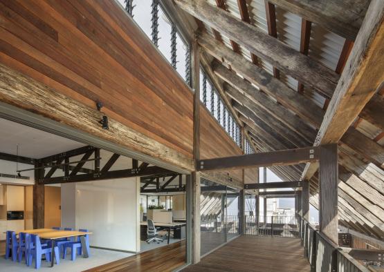 a large wooden building with a blue table and windows