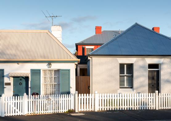 a white picket fence next to a white house