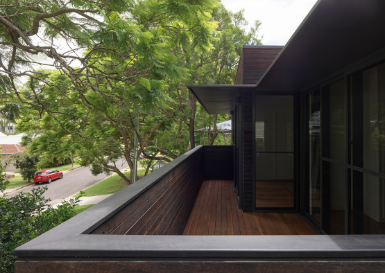 a deck with a wood railing and trees