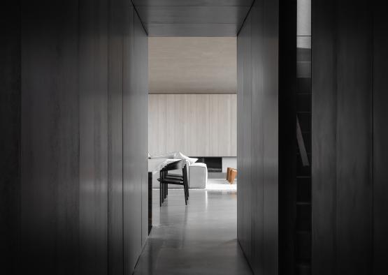 a dark hallway with a chair and a table