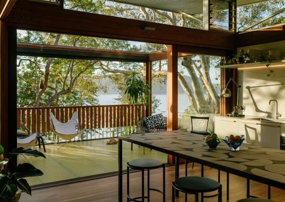 a room with a table and chairs and a hammock on the deck