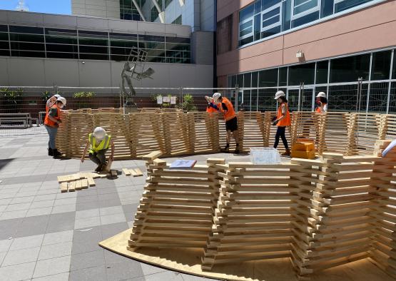 a group of people in orange vests and helmets working on a construction site