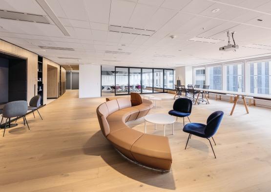 a room with a curved couch and chairs