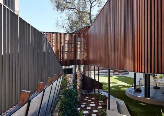 a courtyard with a wood wall and a walkway