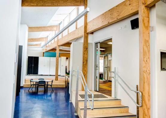 a hallway with stairs and tables