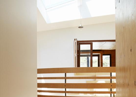 a room with a wooden floor and skylight