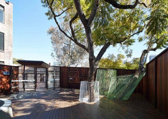 a tree with a fence and a play structure