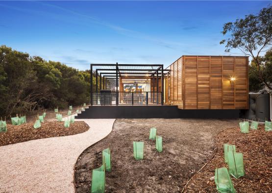 a building with a wooden structure and a gravel path