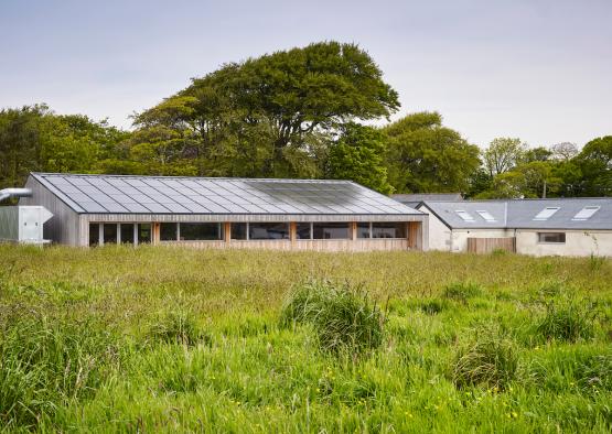 a building with a roof and a field of grass