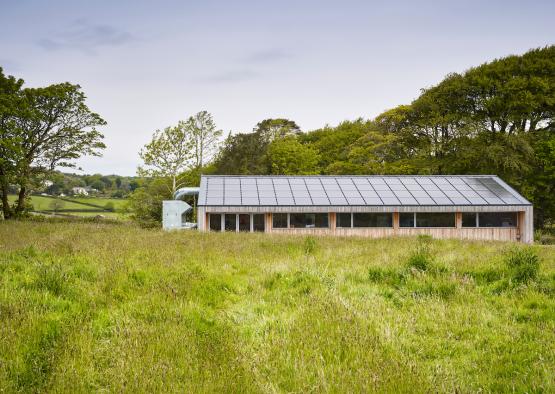 a building with solar panels in a field