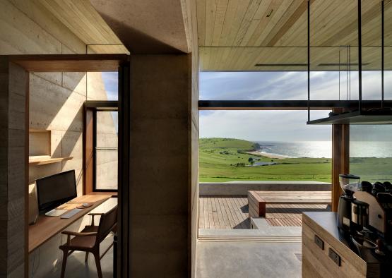 a room with a desk and a view of the ocean