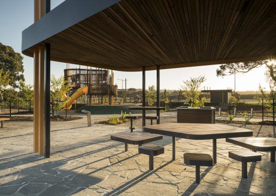 a group of tables and benches under a structure