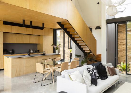 a dog sitting on a couch in a room with a kitchen and dining area