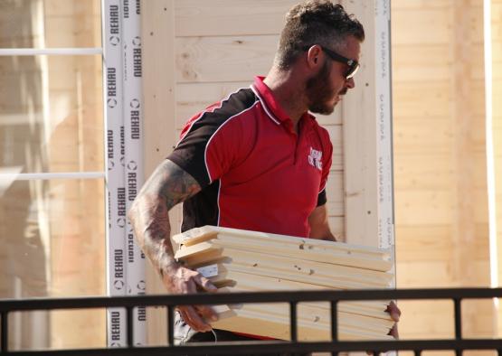 a man carrying a stack of wood