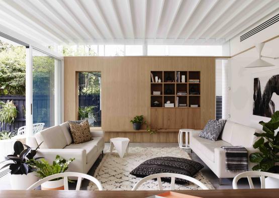 a living room with white couches and a rug