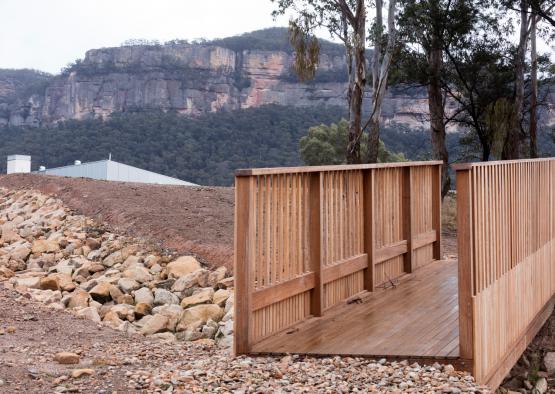 a wooden deck with a rocky hill and trees