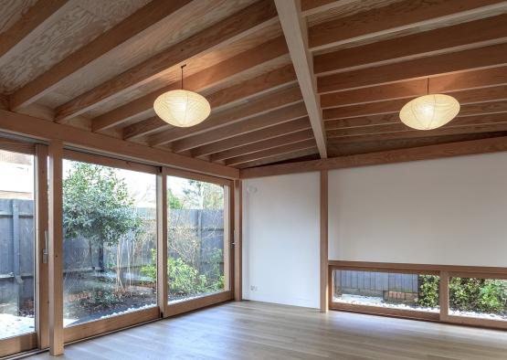 a room with wood beams and ceiling and glass doors