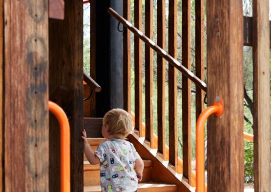 a child climbing up a wooden staircase