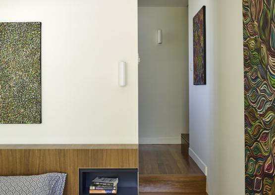 a room with a wood shelf and a painting on the wall