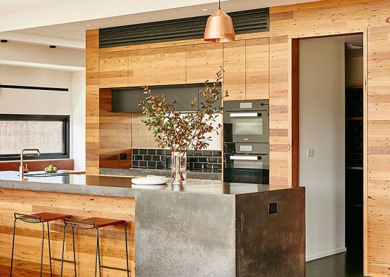 a kitchen with a stone island and a wood wall