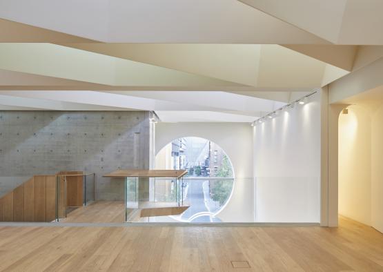 a room with a round window and a concrete wall