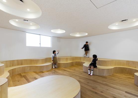 a group of children in a room with wooden benches