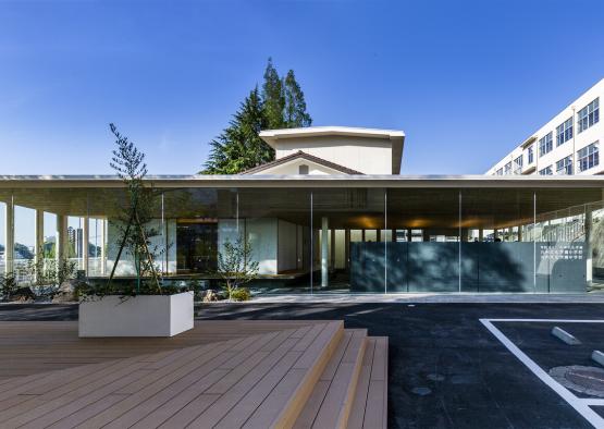 a building with glass walls and a wood deck