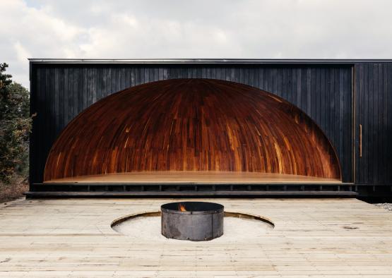 a stage with a circular wooden arch and a fire pit